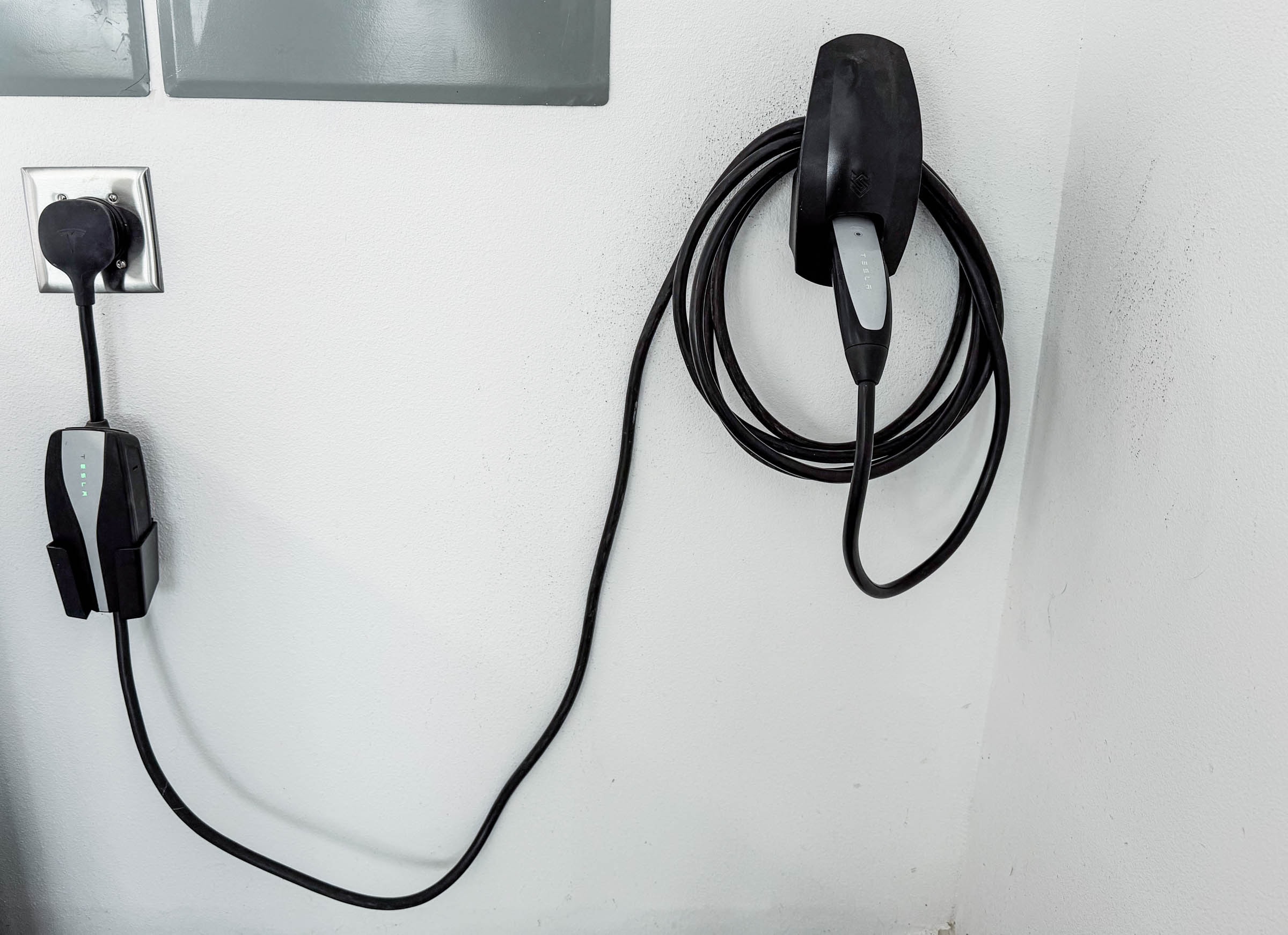 Tesla and universal EV chargers mounted on garage wall