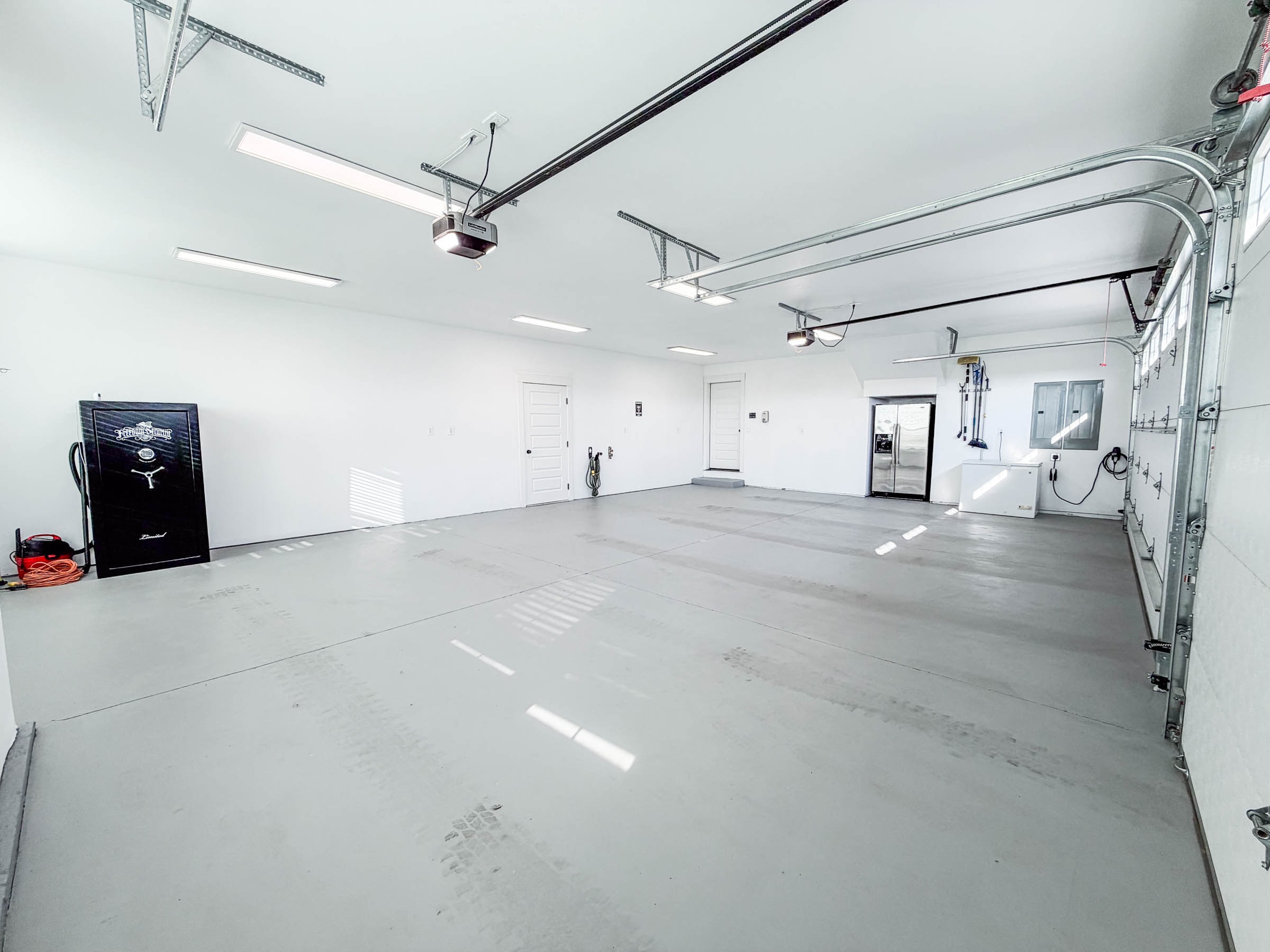 3-car garage interior showing full depth, gun safe, and EV charger on wall