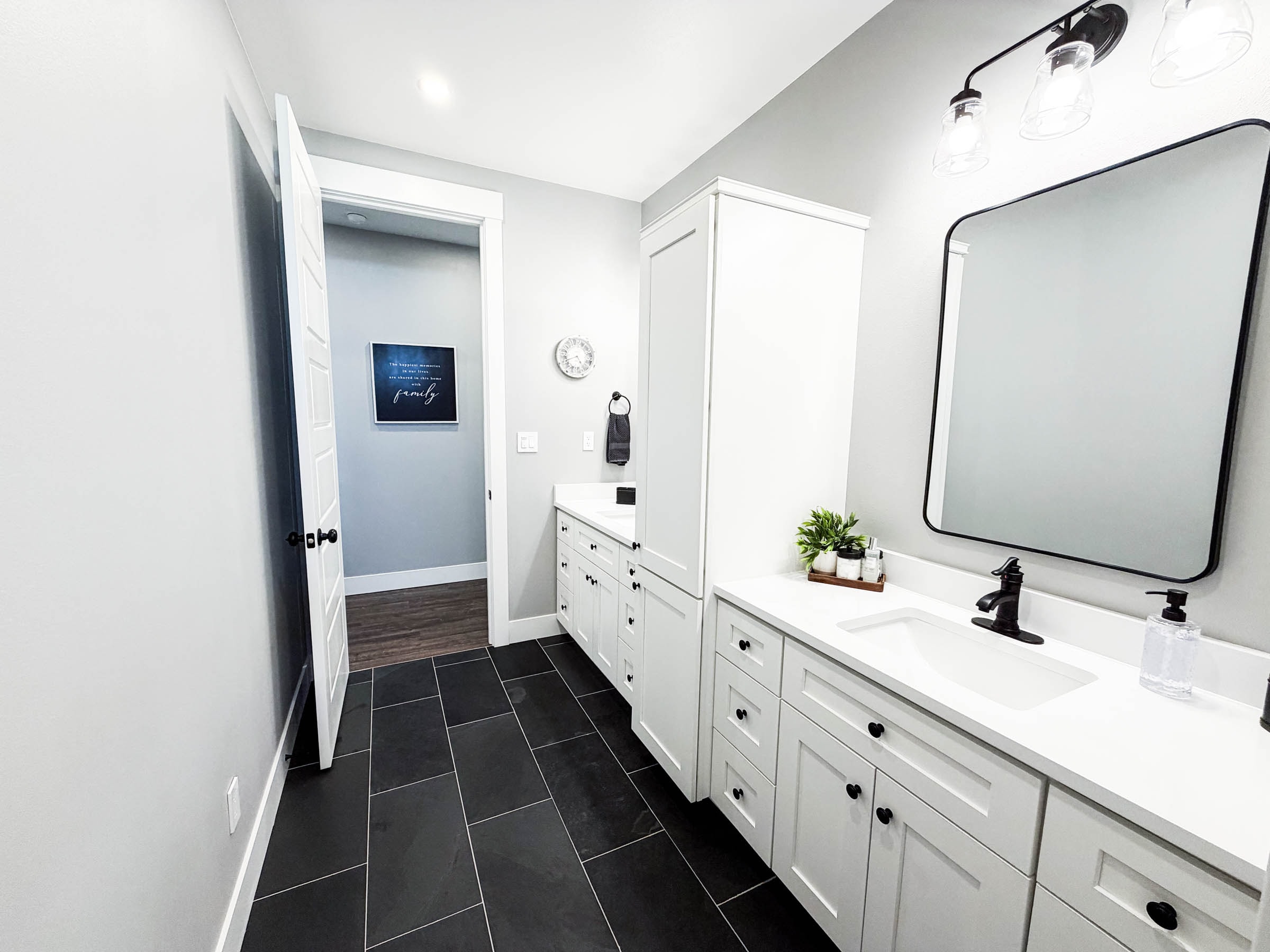 Bath 2 vanities with white shaker cabinets, black hardware, and dark tile floors