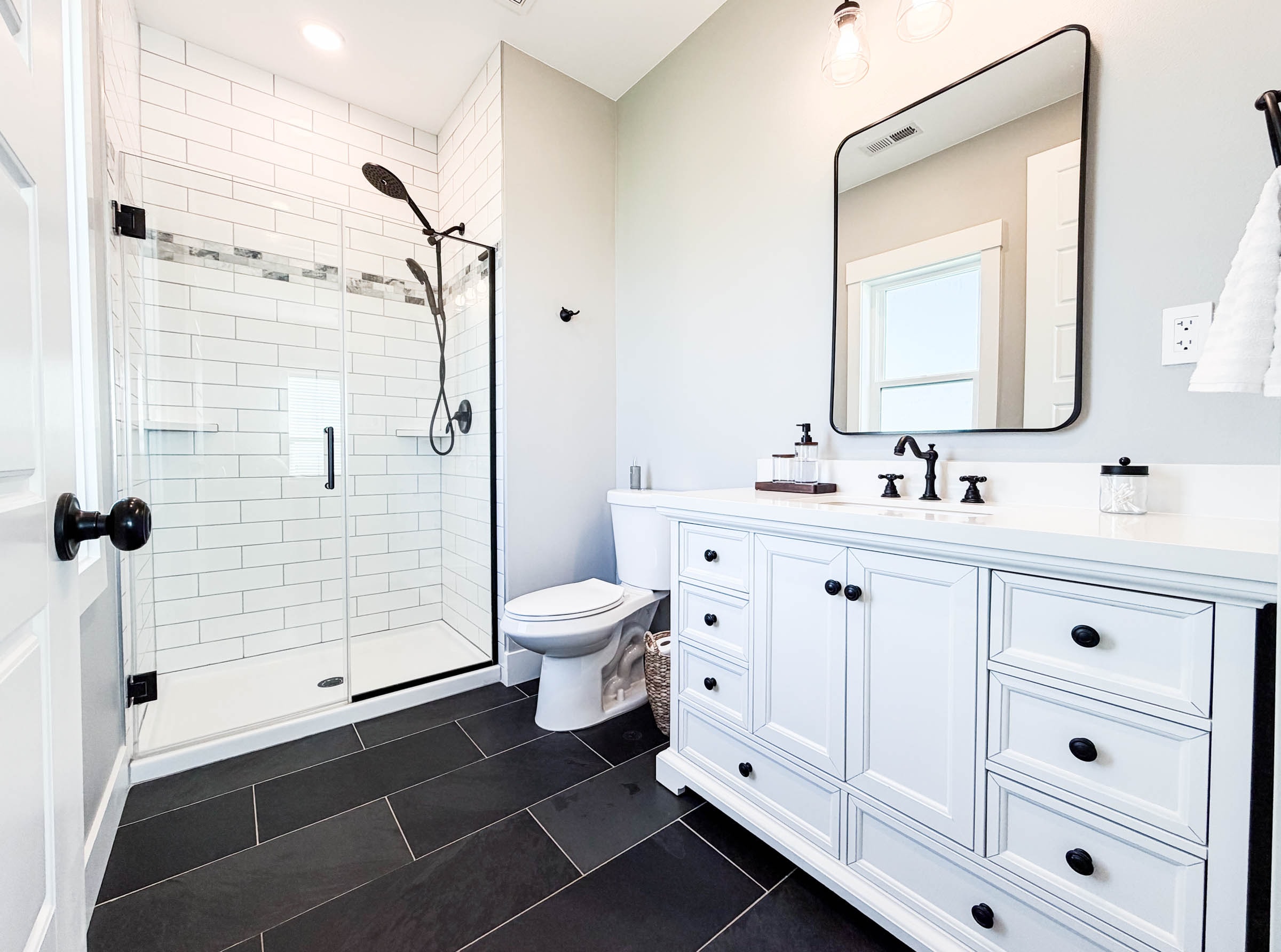 Bath 3 (Bedroom 4) with walk-in glass shower, single vanity, and dark tile floors