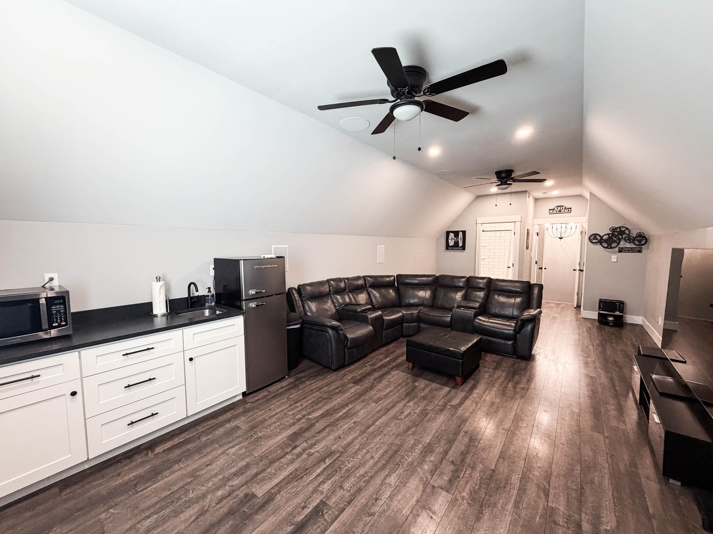 Bonus room with vaulted ceiling, wet bar, and leather sectional