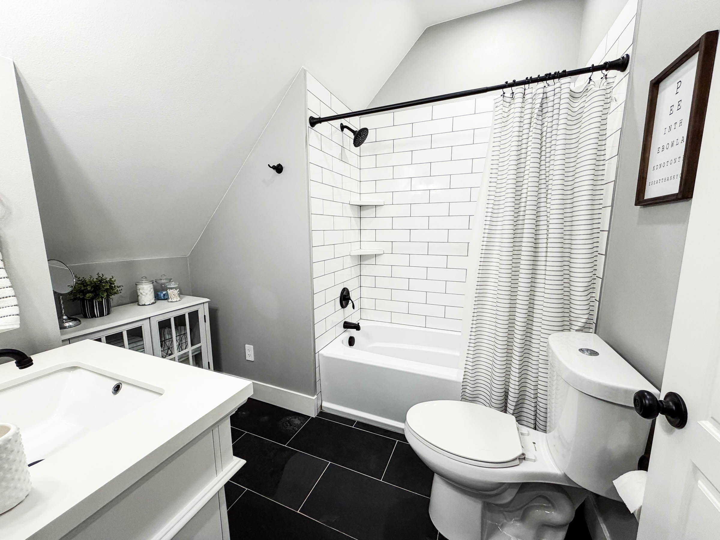 Bonus room bathroom with subway tile shower and black fixtures
