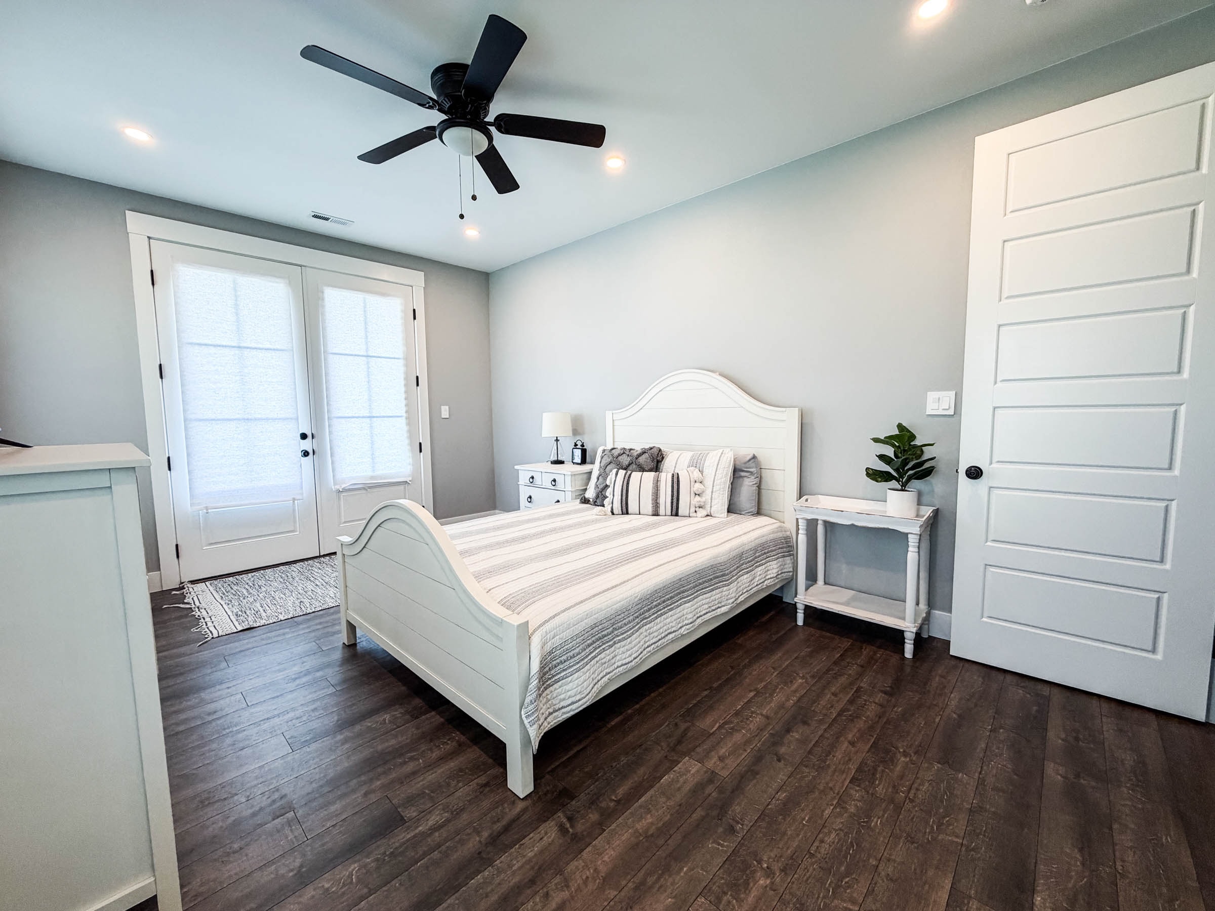 Game room / Bedroom 5 with white bed frame and ceiling fan