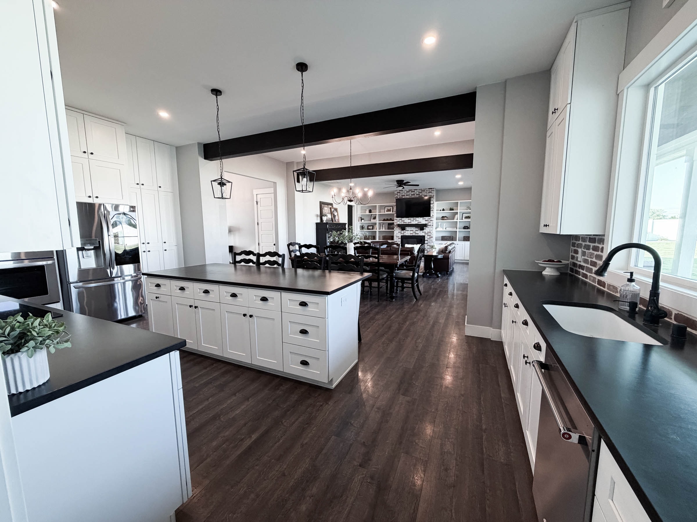 Kitchen looking toward family room with dark wood beams