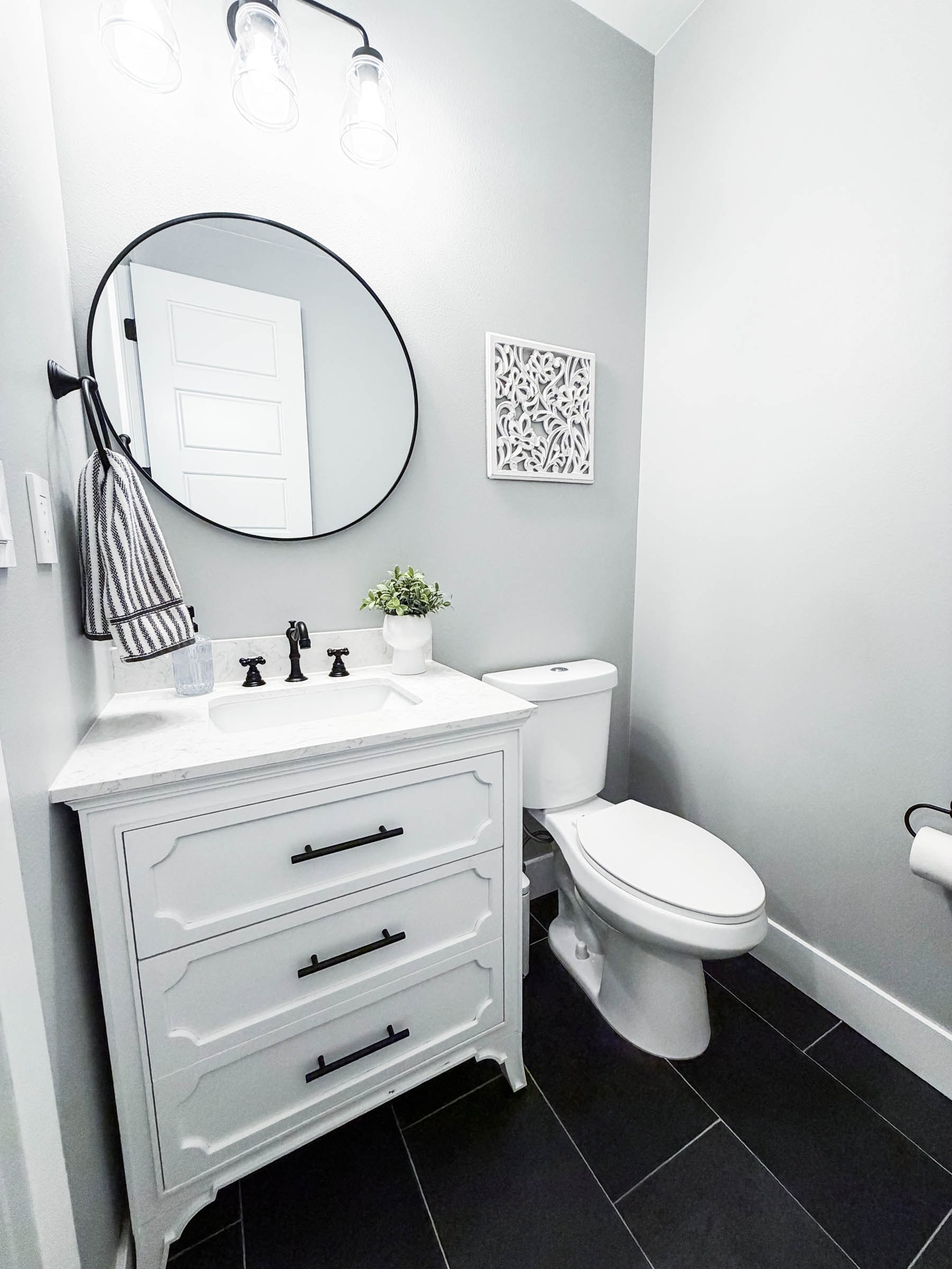 Powder room with white vanity and black fixtures