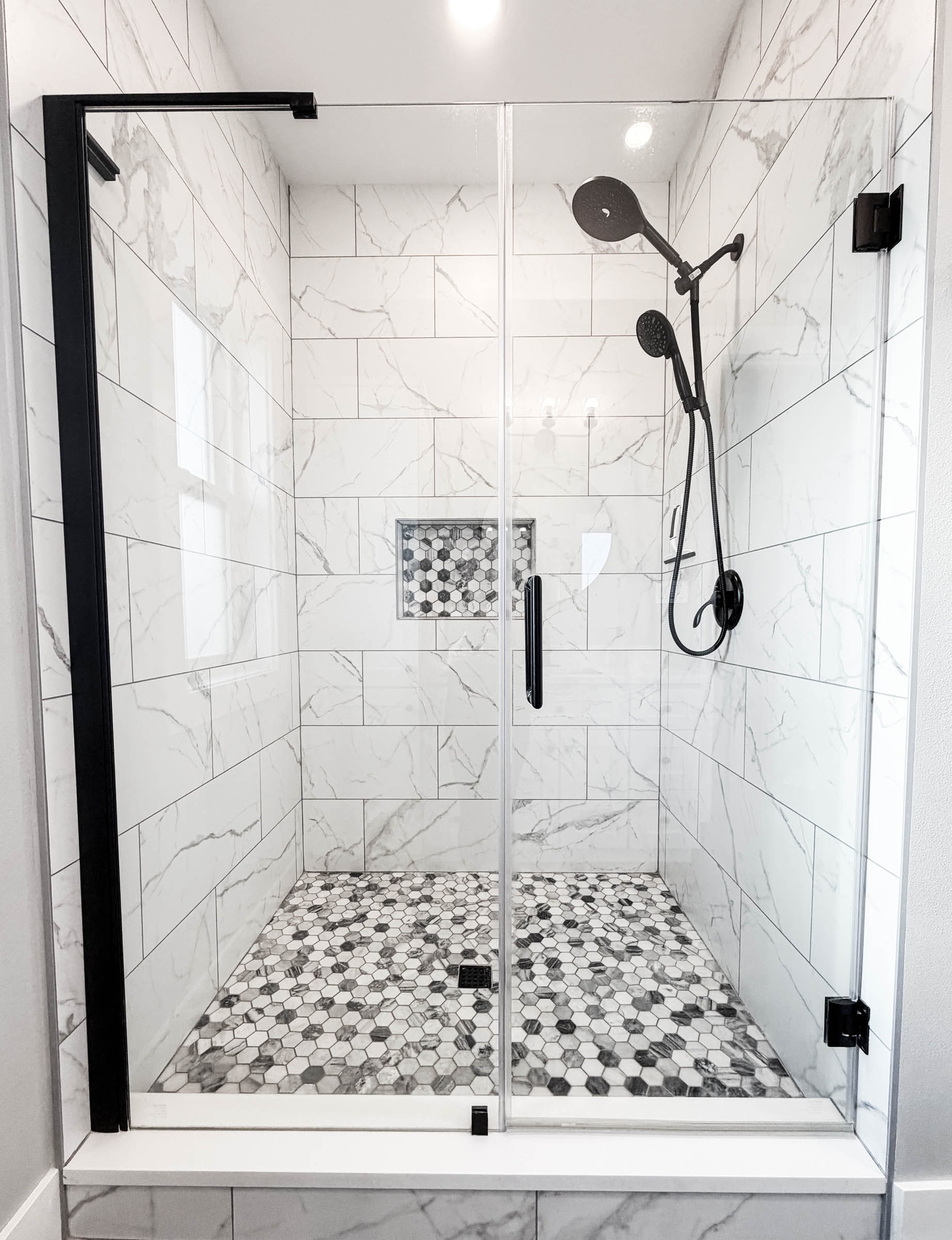 Primary bathroom walk-in shower with marble tile