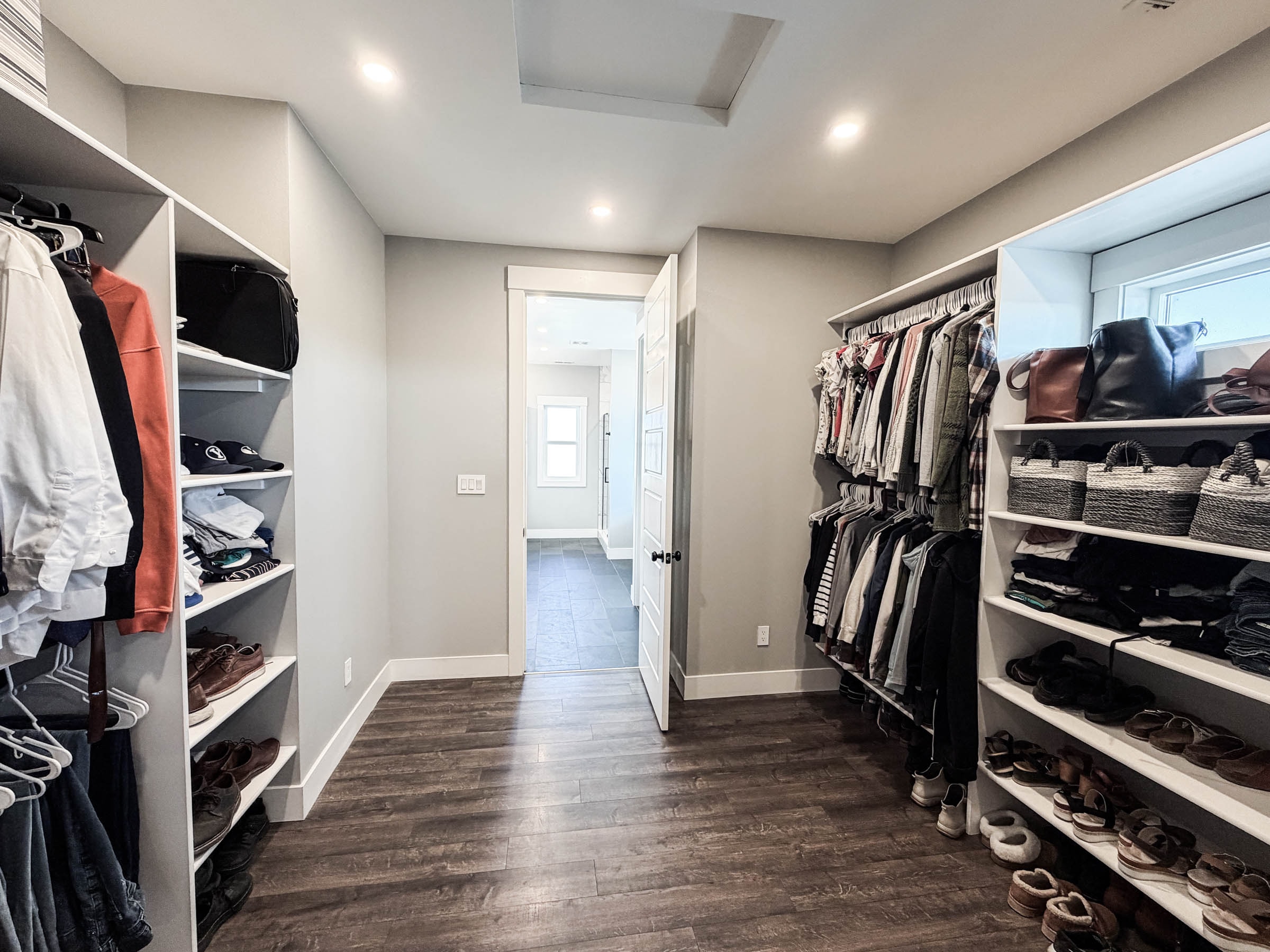 Spacious walk-in primary closet with built-in shelving